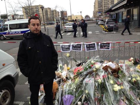 Eric Ellena, at the site of the kosher supermarket siege, pays his respect to the dead. (photo by Ian Ayres)